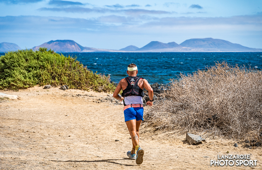 A runner with views of La Graciosa in the Famara total race