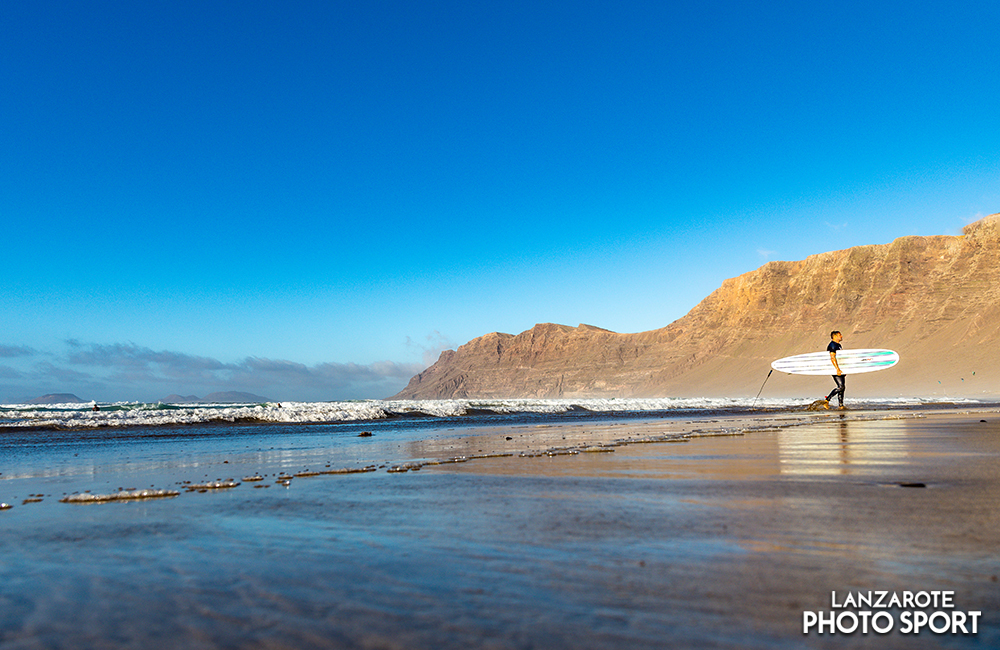 Surfista saliendo del agua en playa de Famara